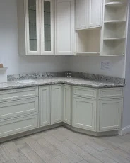 Cream raised-panel cabinets with a speckled grey granite countertop, PA Home Supply showroom