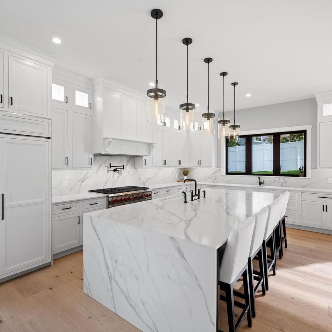 White kitchen with a marble-look waterfall island, materials from PA Home Supply
