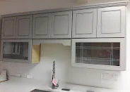 Grey shaker cabinets with glass-front uppers and a granite countertop, PA Home Supply showroom
