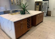 Walnut-tone cabinetry with a white waterfall quartz island and built-in wine storage, PA Home Supply showroom