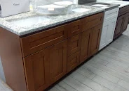 Walnut-tone shaker cabinets with a waterfall quartz countertop island, PA Home Supply showroom
